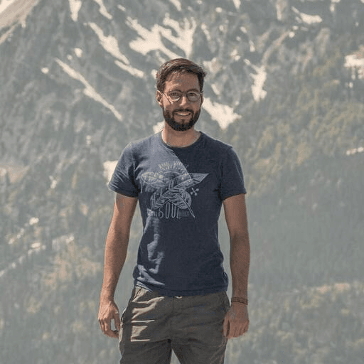 image of Andres Cortez standing in front of a mountain wearing a blue tee shirt